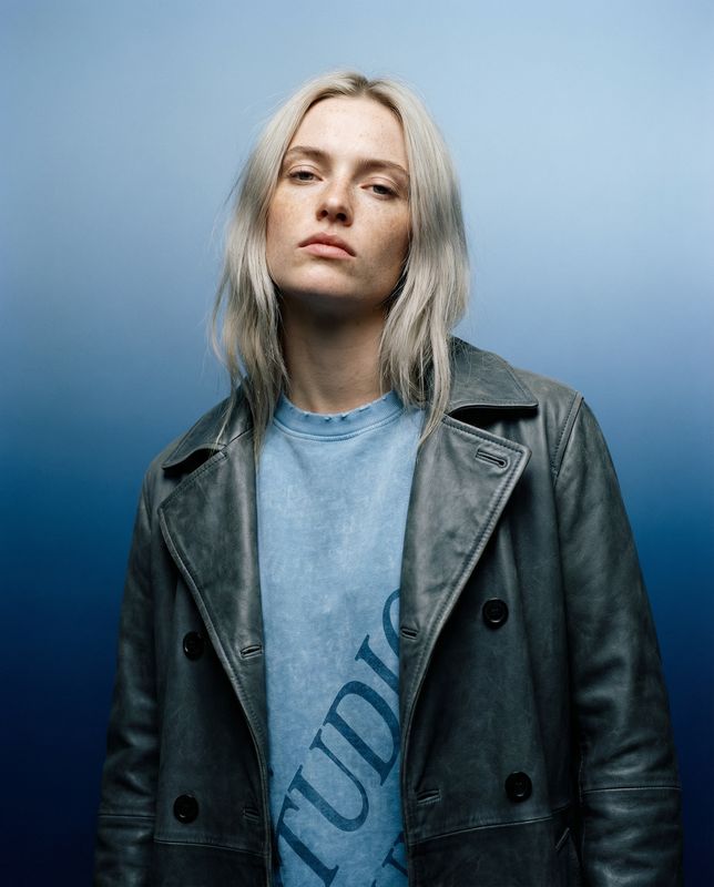 a woman with blonde hair wearing a leather jacket