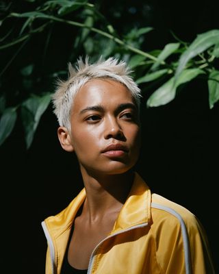a woman with white hair and a yellow jacket