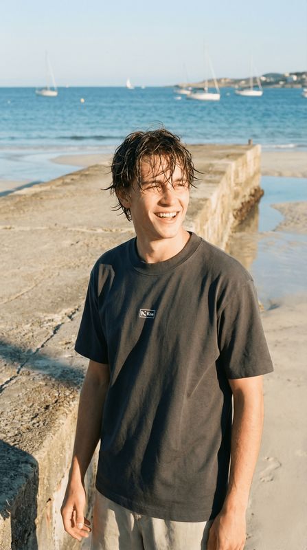 a man standing on a beach next to the ocean