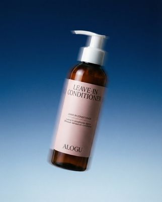 a bottle of leave - in conditioner on a blue background