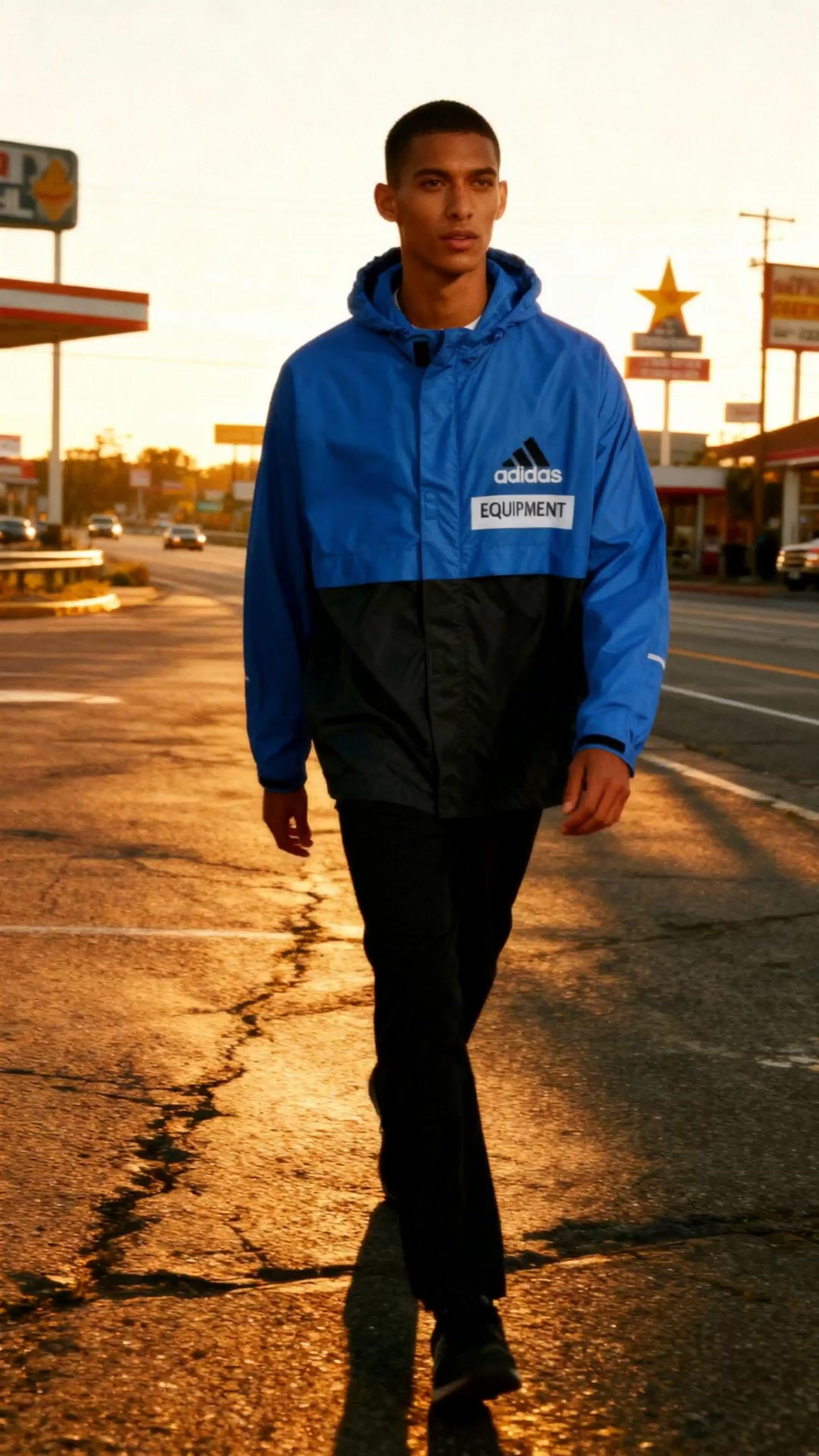 a man in a blue jacket is walking down the street