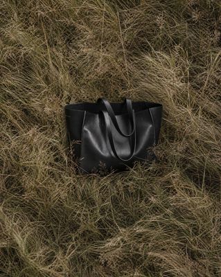 a black bag laying in a field of grass