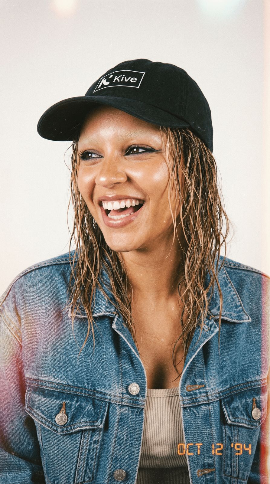 a woman wearing a denim jacket and a hat
