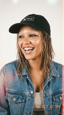 a woman wearing a denim jacket and a hat