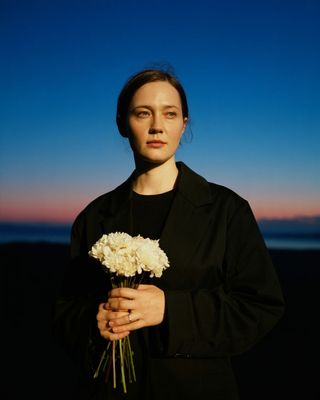 a woman holding a bouquet of white flowers
