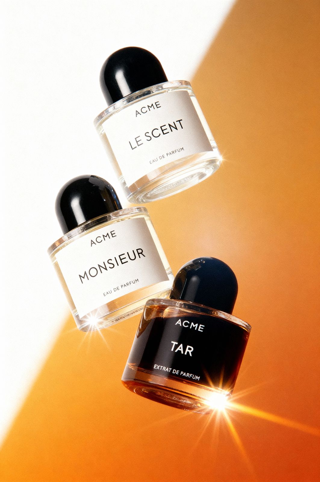 three bottles of perfume on an orange background