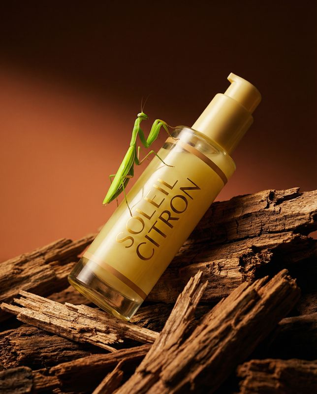 a close up of a bottle of perfume on a pile of wood