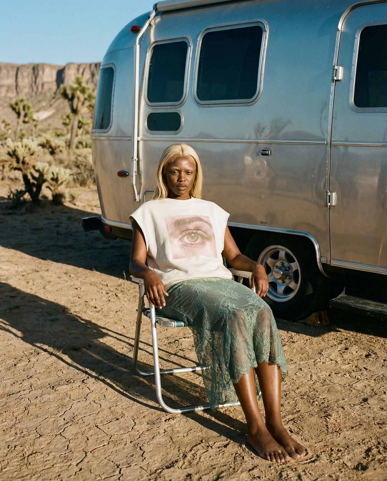 a woman sitting in a chair in front of a trailer