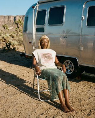 a woman sitting in a chair in front of a trailer