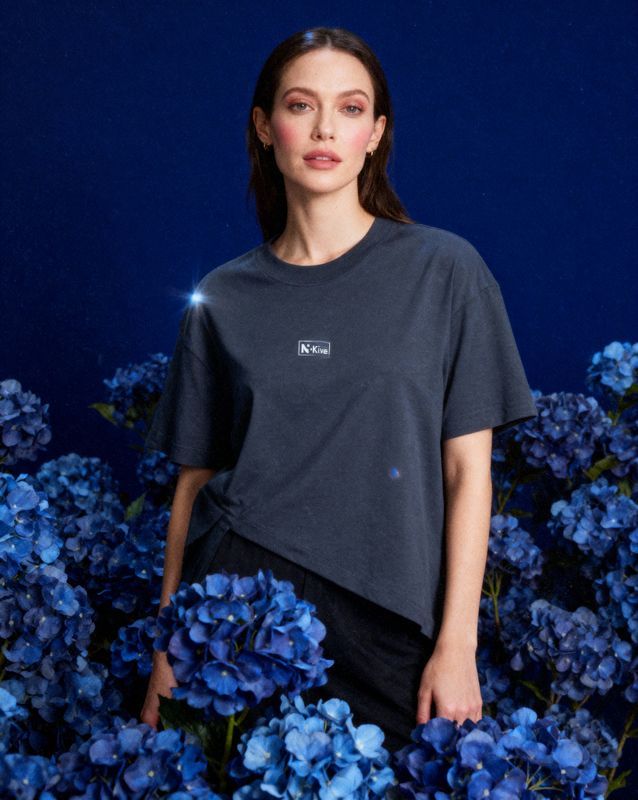 a woman standing in a field of blue flowers