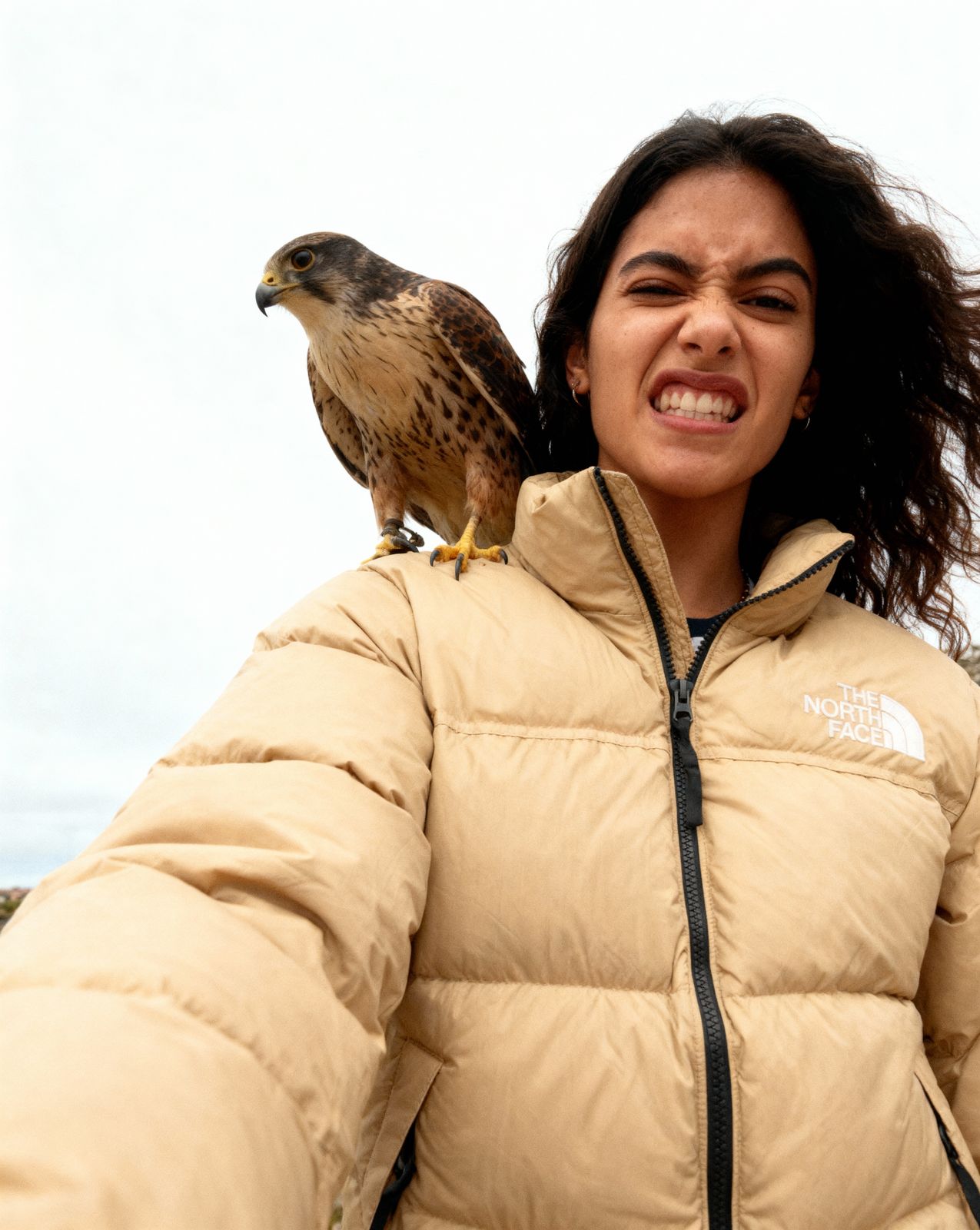 a woman holding a falcon on her shoulders