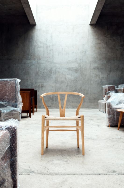 a chair sitting in a room with a skylight above it