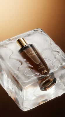 a bottle of perfume sitting on top of an ice block