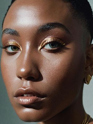 a close up of a woman with gold makeup