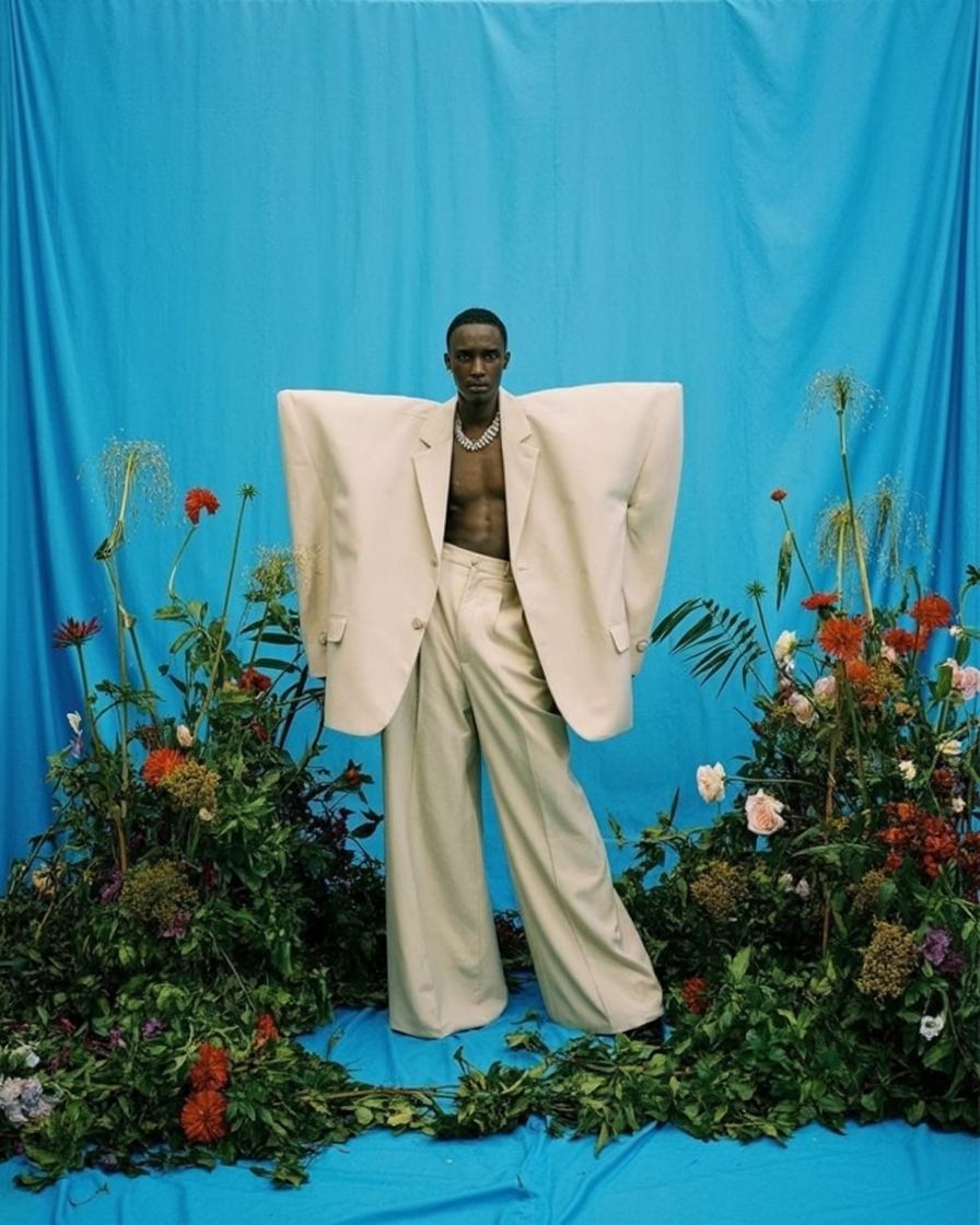 a statue of a man standing in front of a blue backdrop