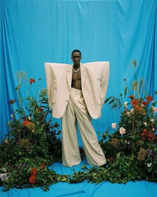a statue of a man standing in front of a blue backdrop