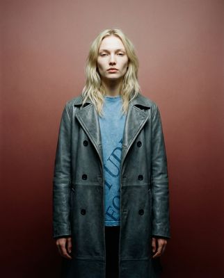a woman standing in front of a red wall