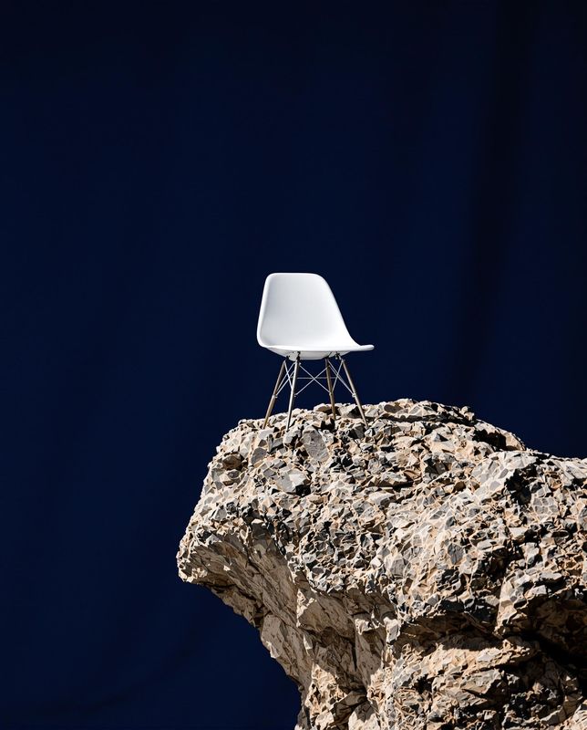 a white chair sitting on top of a rock