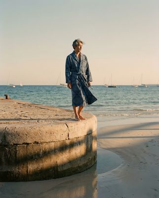 a man standing on a cement wall near the ocean