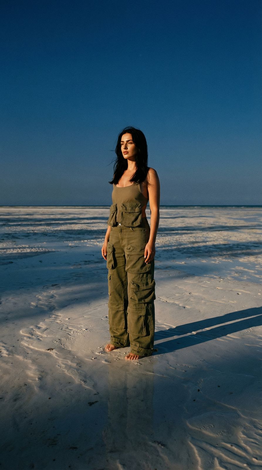 a woman standing in the snow with her hands in her pockets