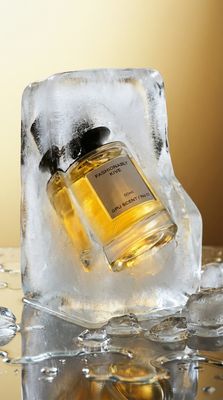 a bottle of cologne sitting on top of an ice block