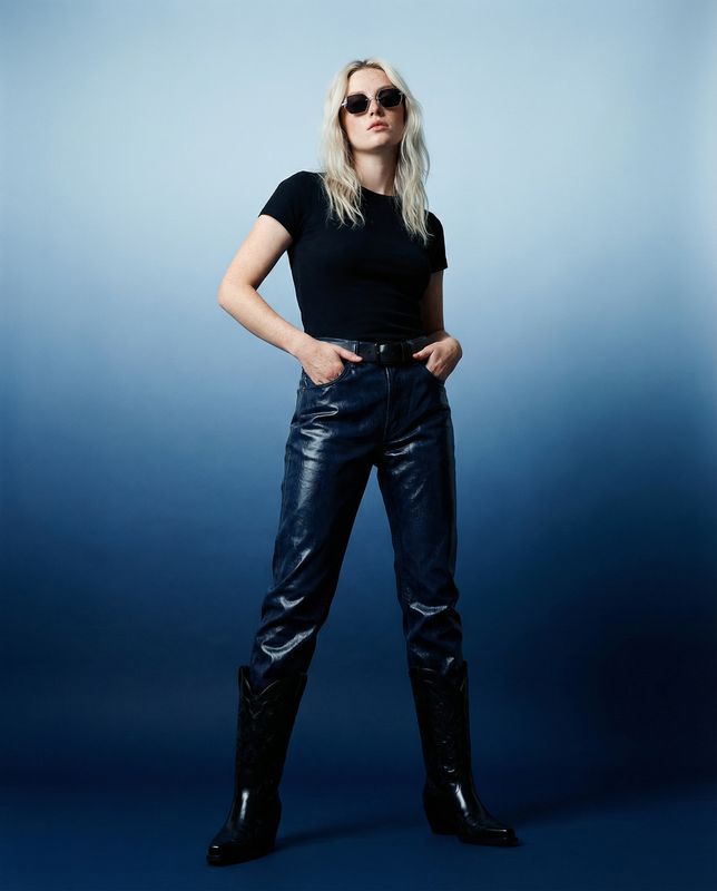 a woman in a black shirt and leather pants