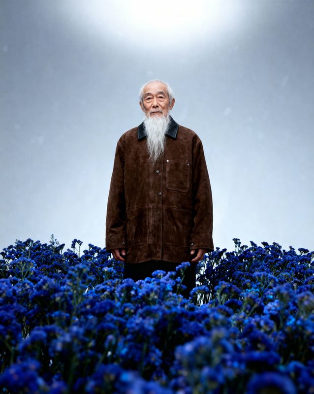 a man standing in a field of blue flowers