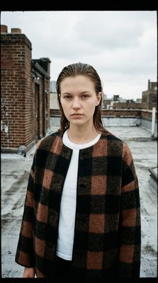 a woman standing in front of a brick building