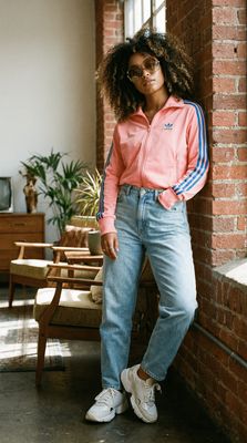 a woman leaning against a brick wall