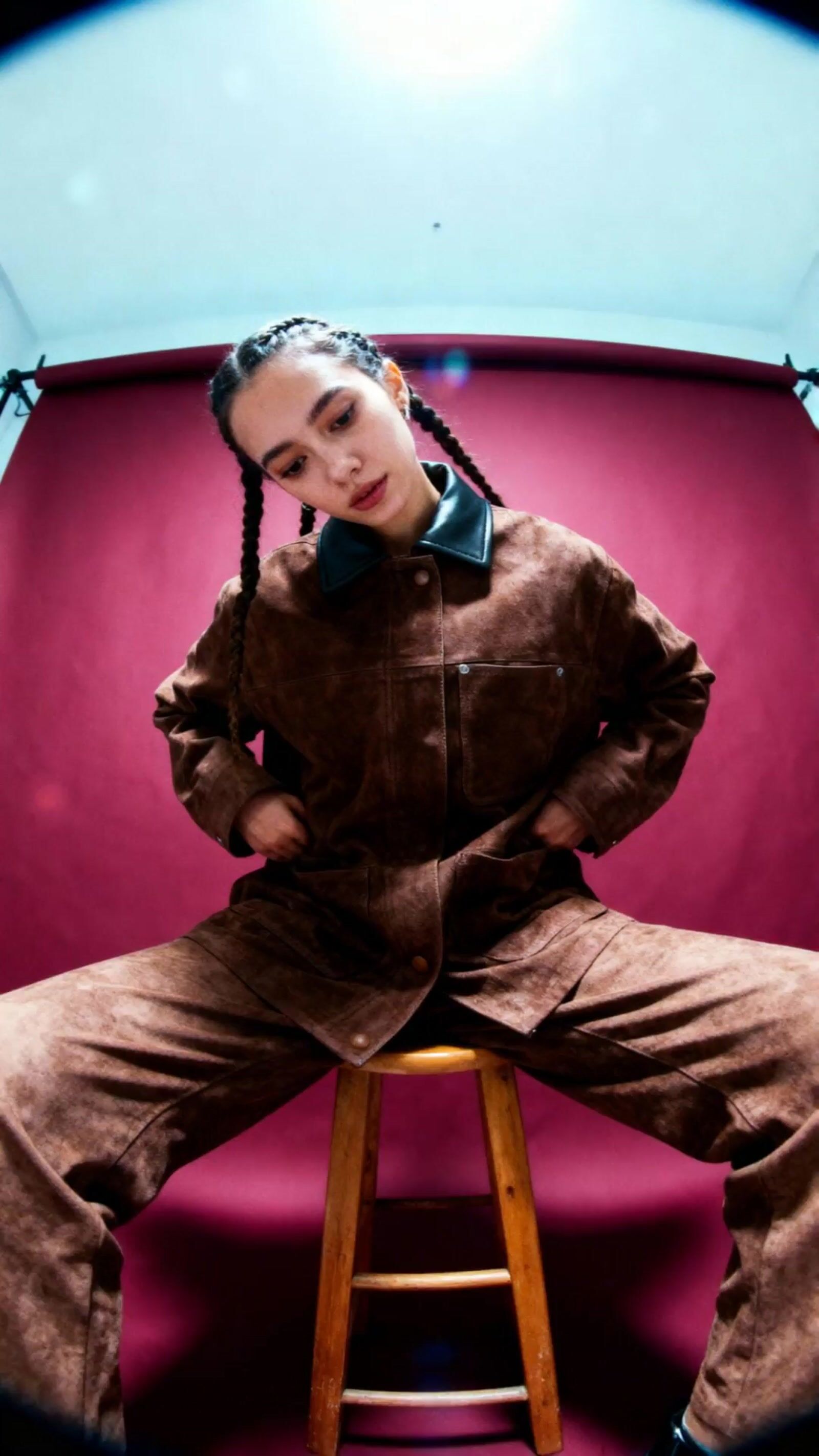 a woman sitting on top of a wooden stool