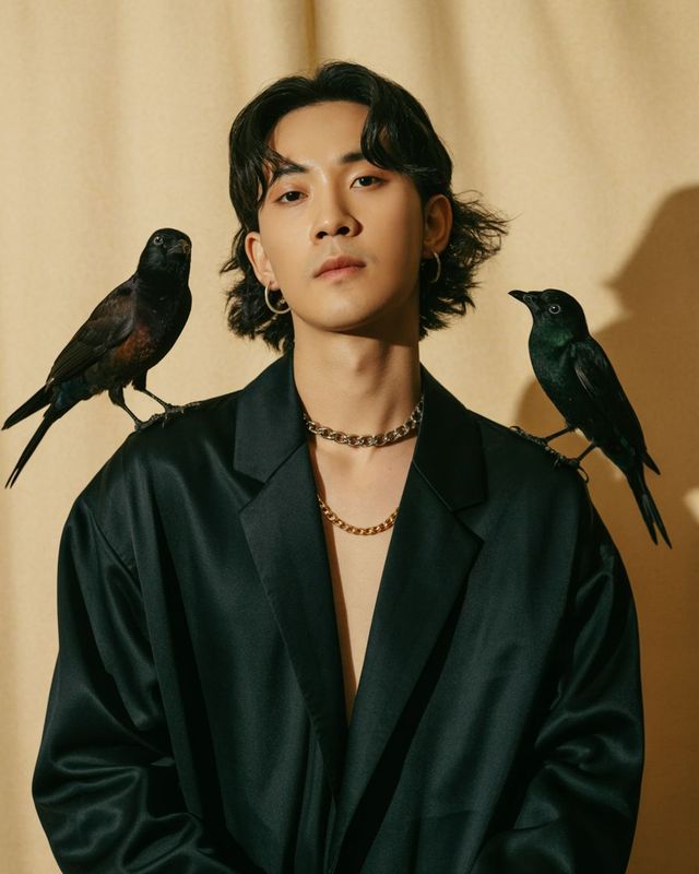 a man with two birds on his shoulders