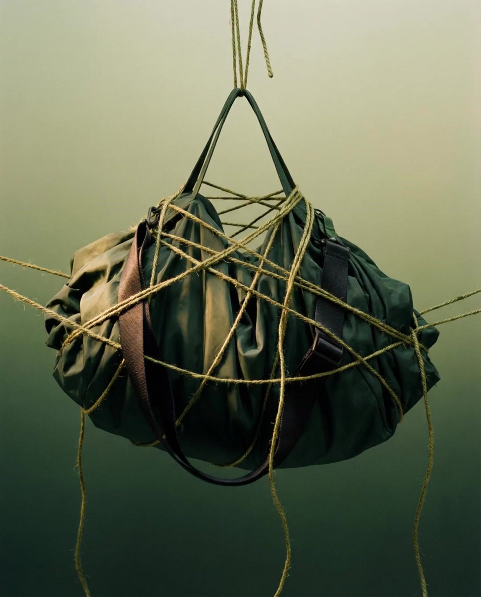 a green bag hanging from a rope in the water