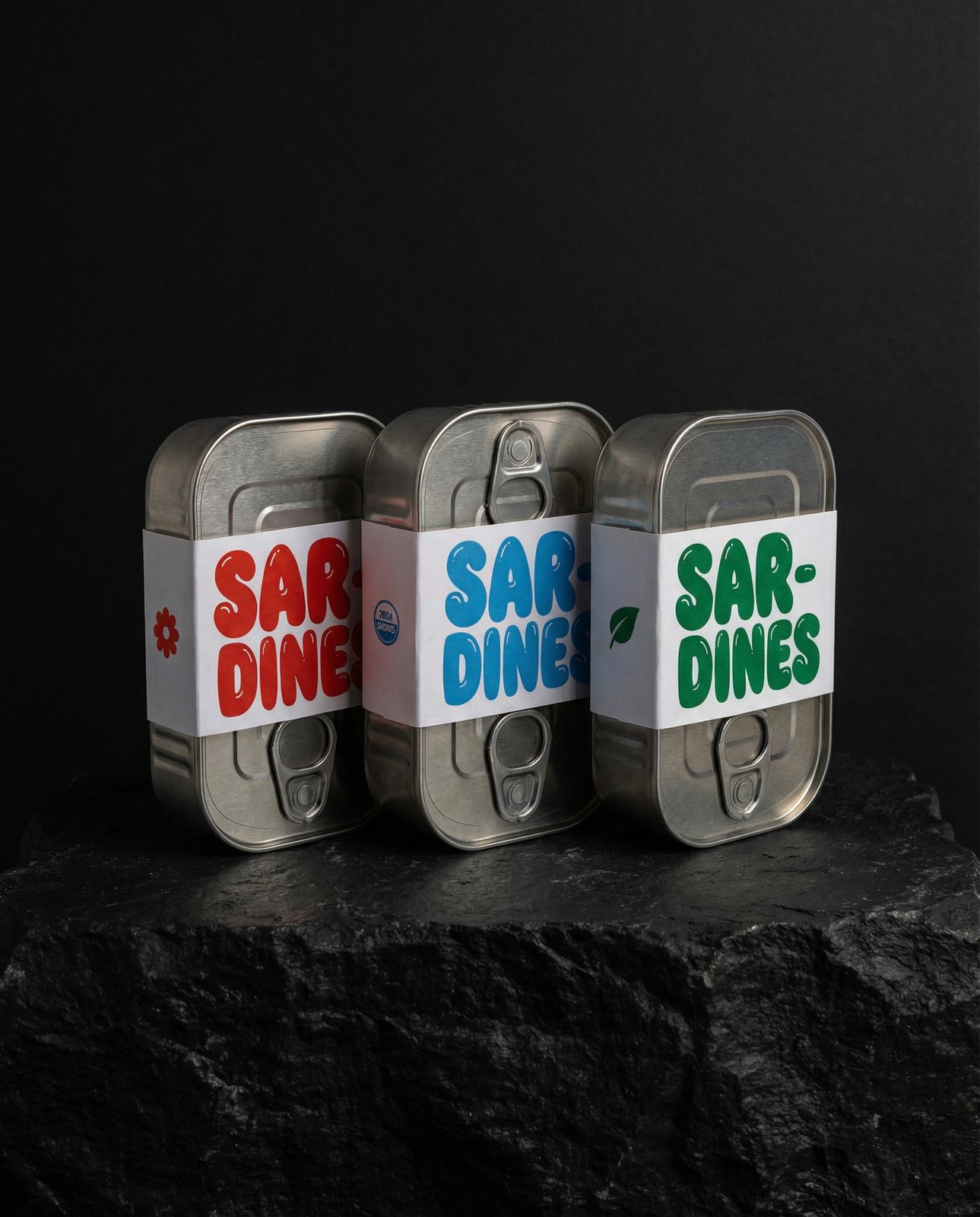 three tins of food sitting on top of a rock