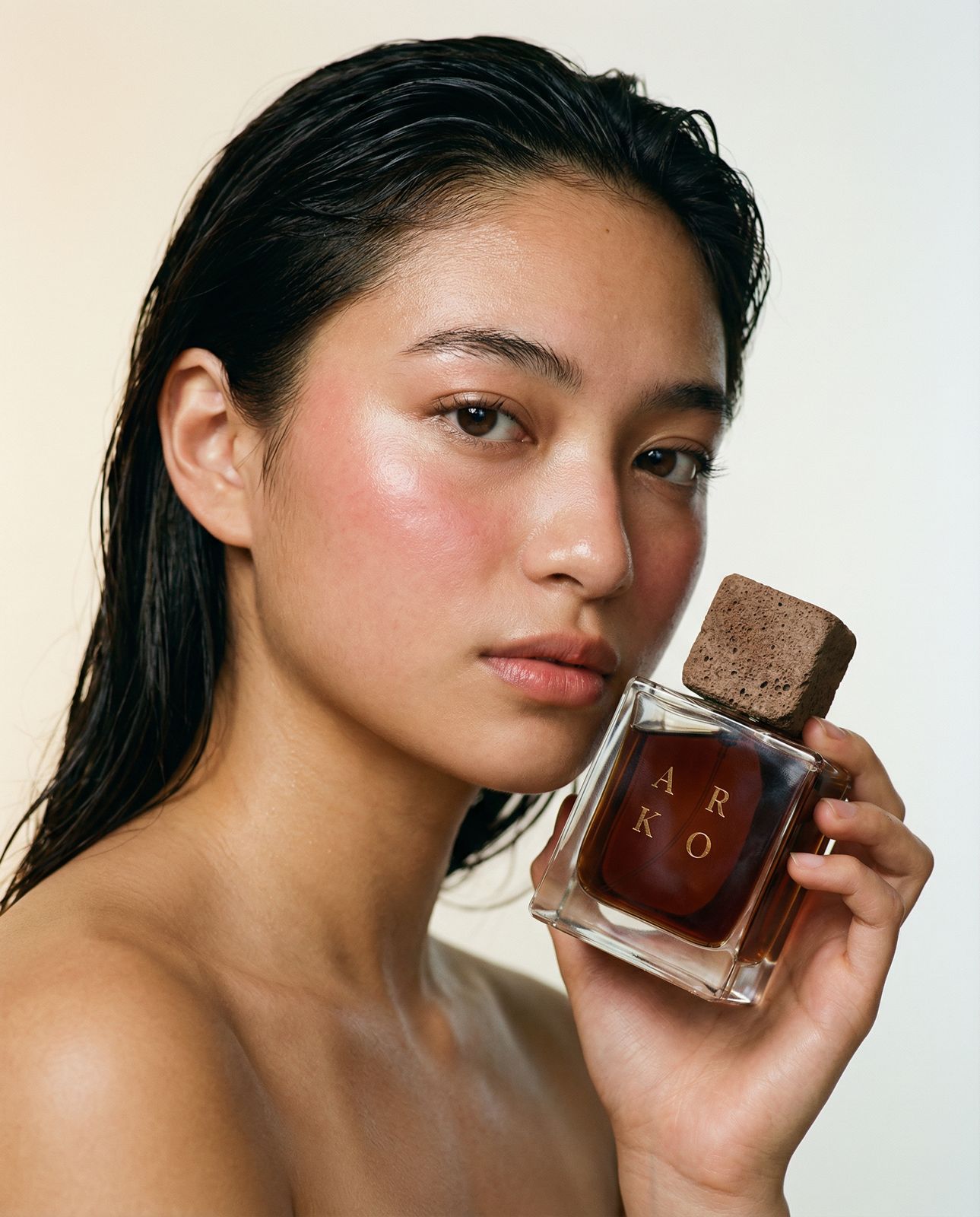 a woman holding a bottle of perfume in her hand