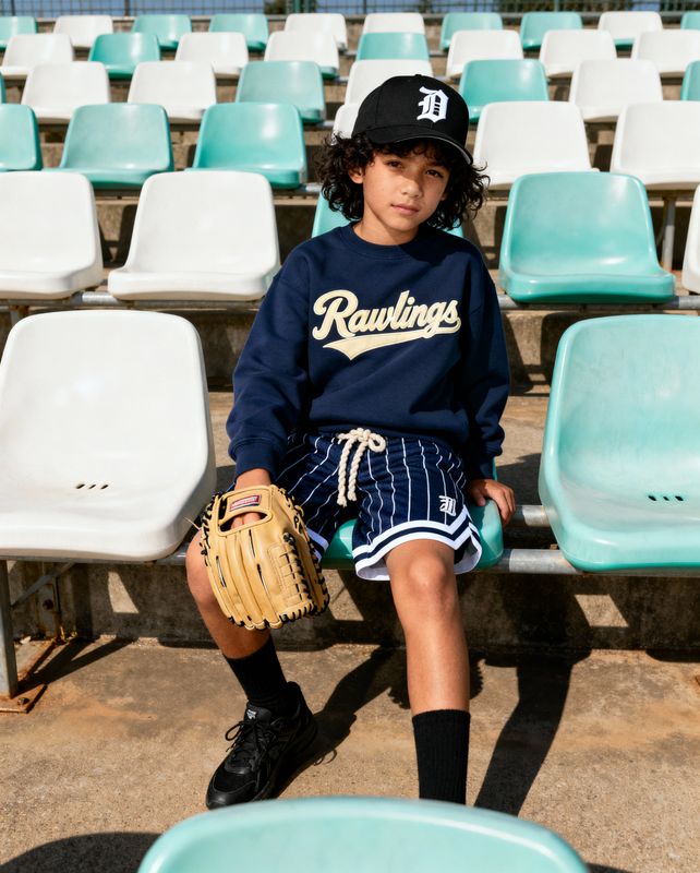 a young boy sitting on a bench with a baseball glove