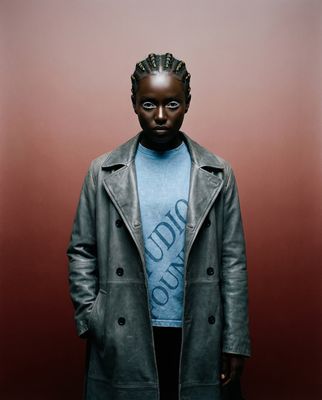 a man wearing a blue shirt and a gray coat