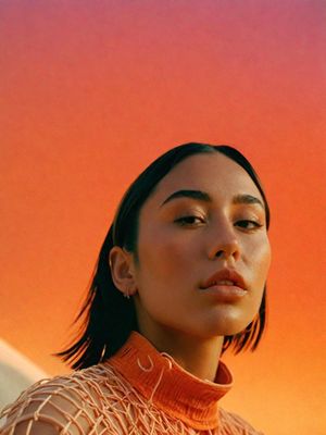 a woman wearing a turtle neck sweater and earrings