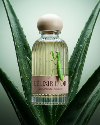 a close up of a bottle of perfume on a plant