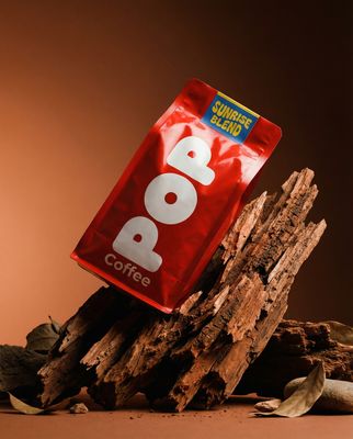 a bag of coffee sitting on top of a pile of wood