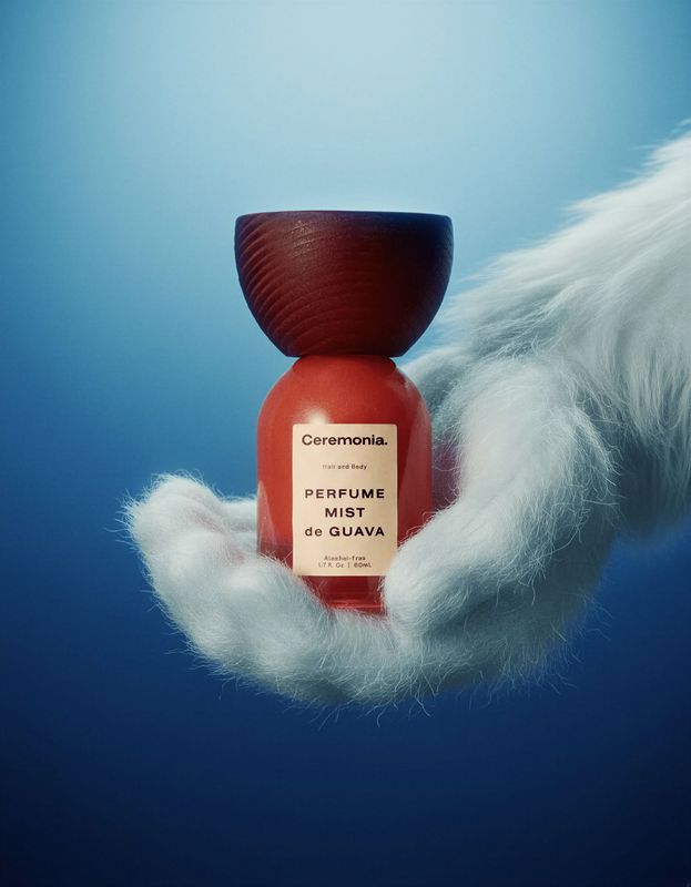 a hand holding a bottle of perfume in the air