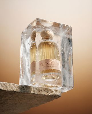 a bottle of perfume sitting on top of an ice block