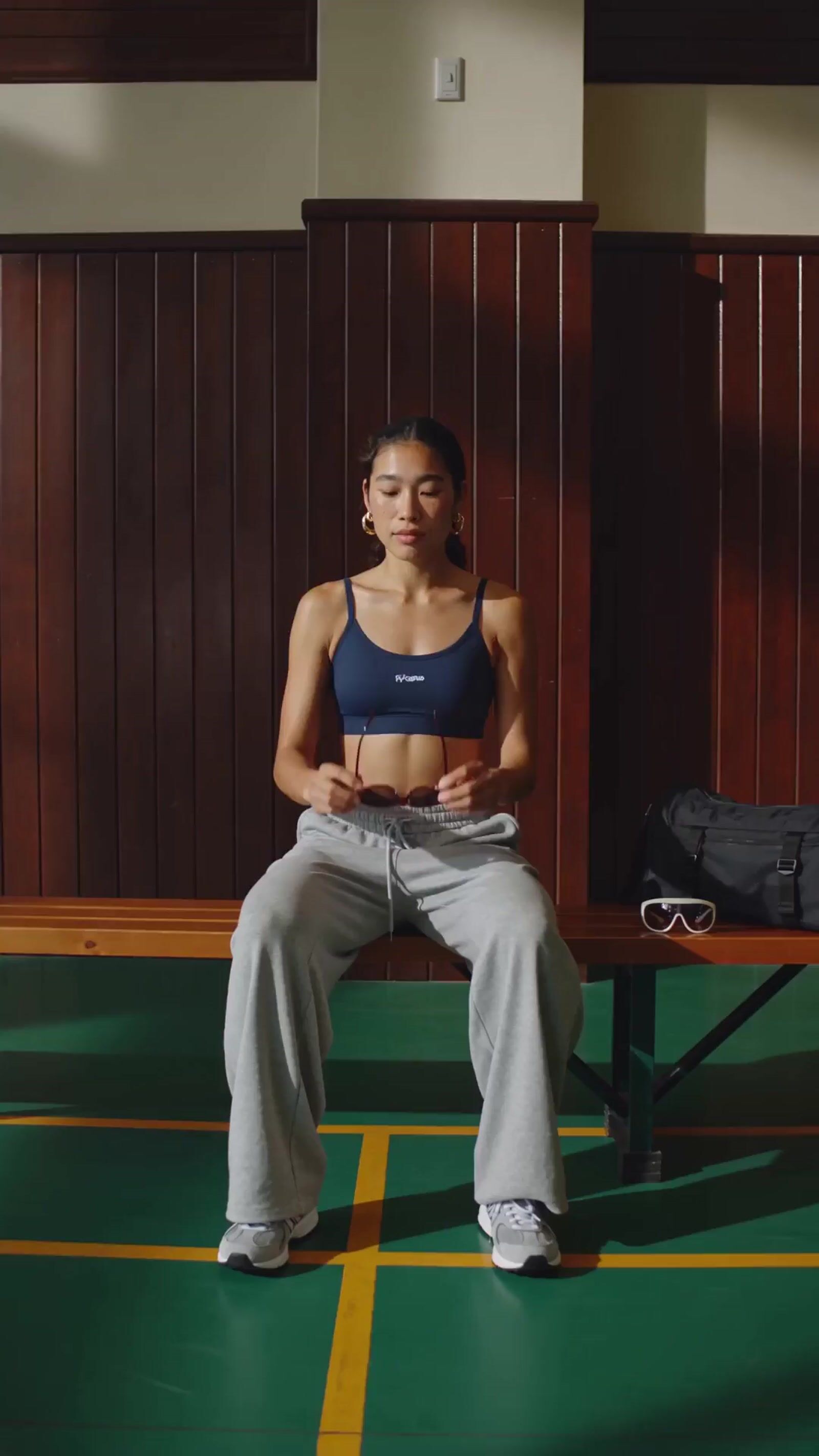 a woman sitting on a bench in a gym