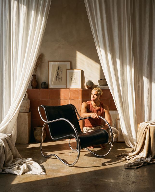 a man sitting in a chair in front of a window
