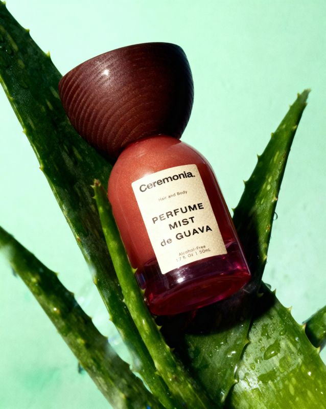 a bottle of perfume sitting on top of a plant