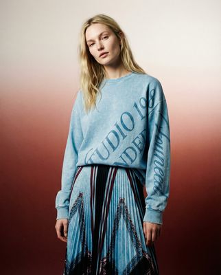 a woman in a blue sweater and skirt