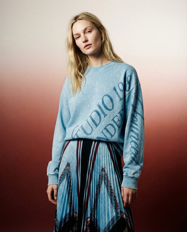 a woman in a blue sweater and skirt