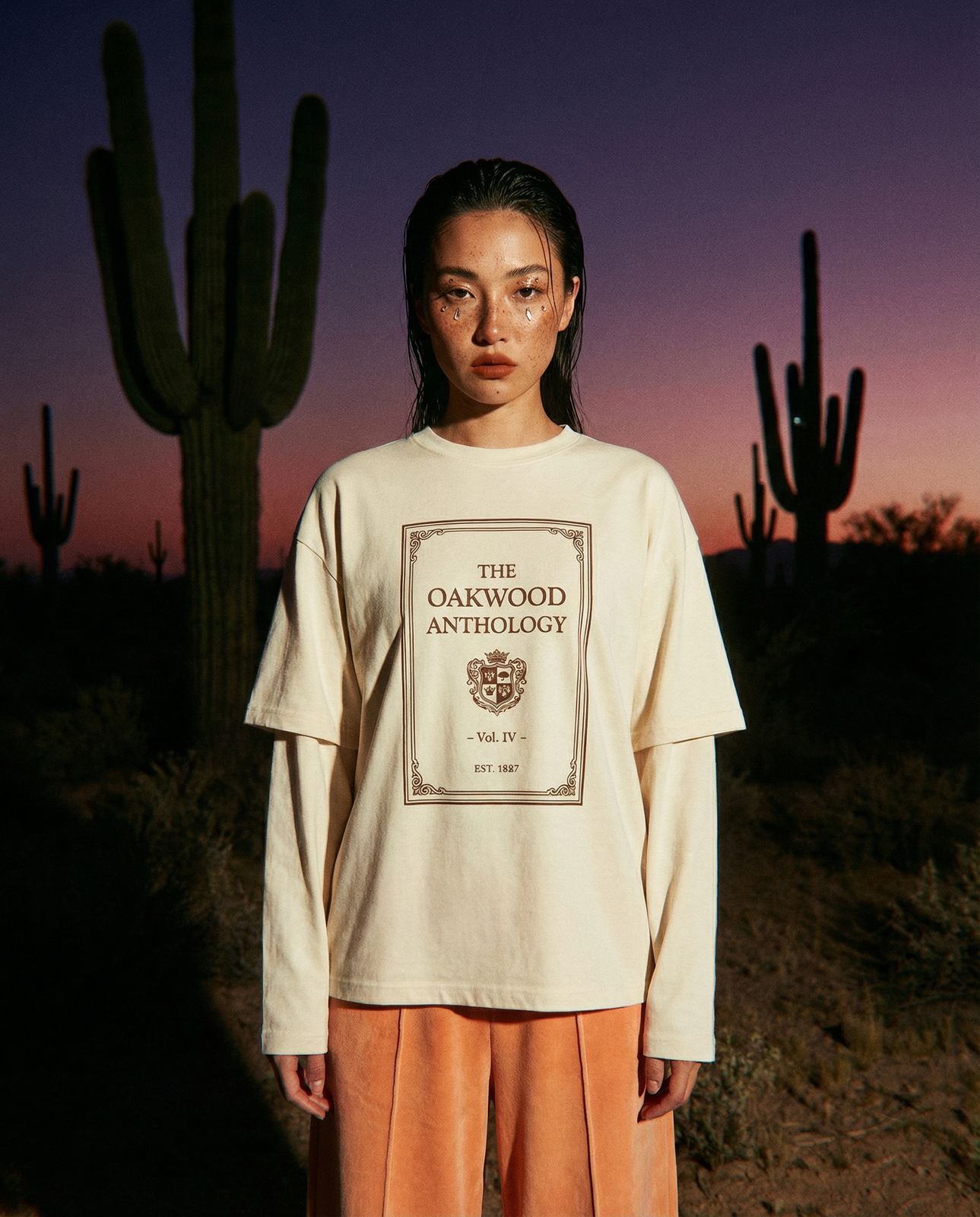 a woman standing in front of a cactus