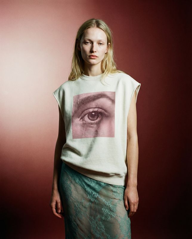 a woman standing in front of a red wall