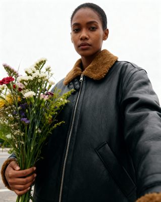a woman holding a bunch of flowers in her hands