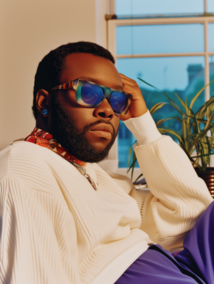 a man in a white sweater and blue sunglasses